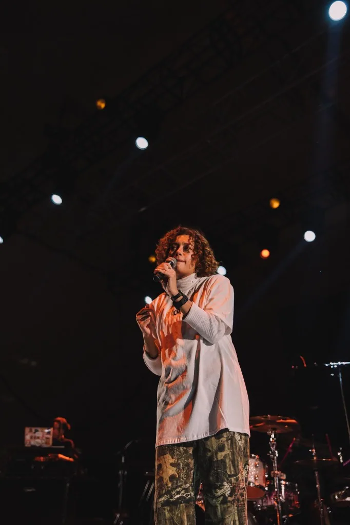 Atmospheric live performance on a dark stage with warm amber lighting.